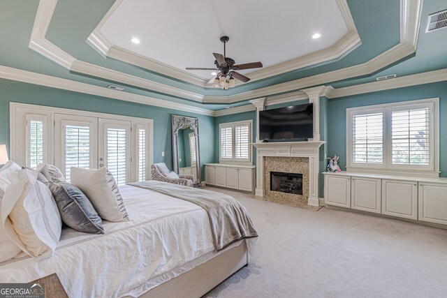 carpeted bedroom with multiple windows, ceiling fan, and a high end fireplace