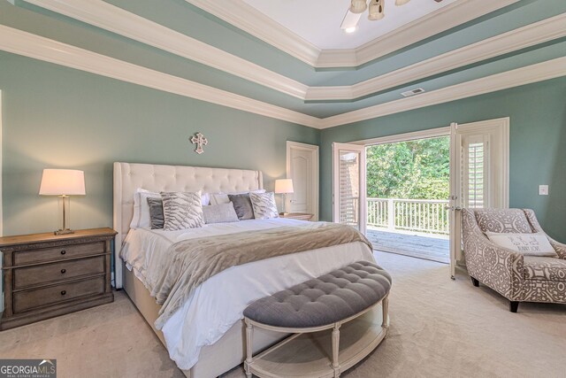 carpeted bedroom with ornamental molding, access to outside, and a tray ceiling