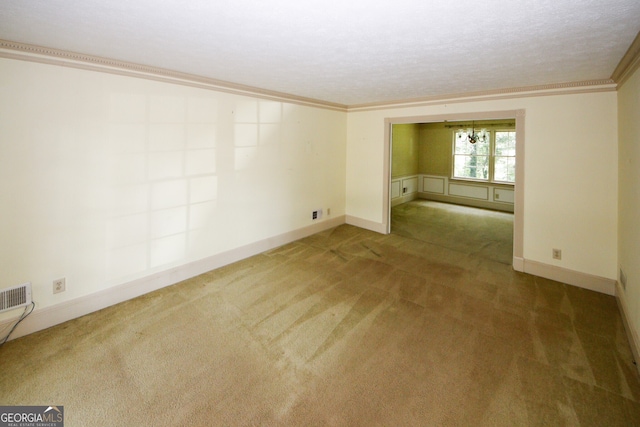 unfurnished room featuring a textured ceiling, carpet, baseboards, and crown molding