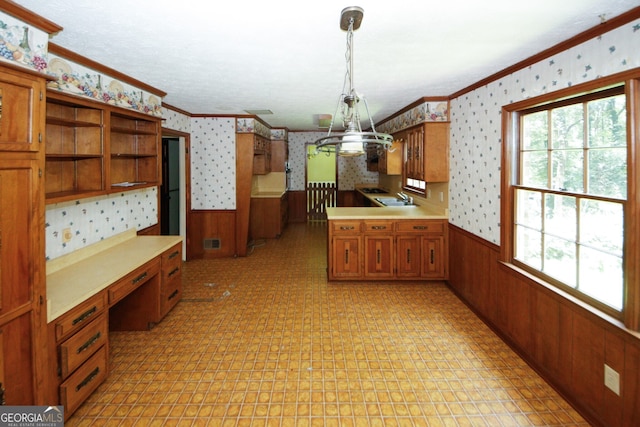 kitchen featuring a wainscoted wall, decorative light fixtures, and wallpapered walls