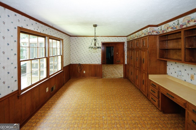 unfurnished dining area with light floors, visible vents, wainscoting, built in study area, and wallpapered walls