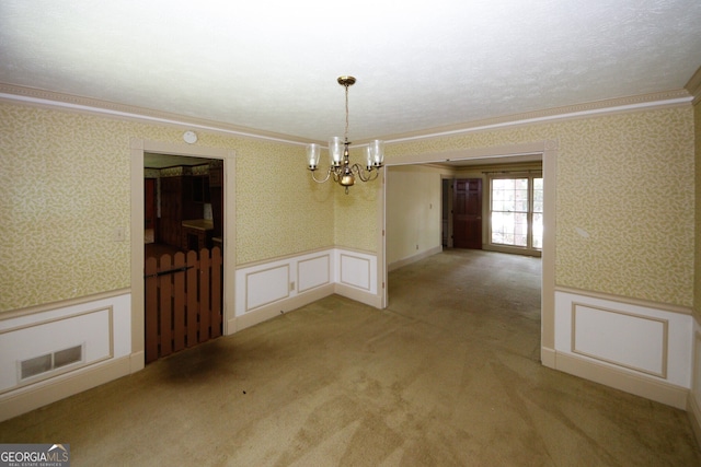 unfurnished dining area with wallpapered walls, visible vents, crown molding, and wainscoting