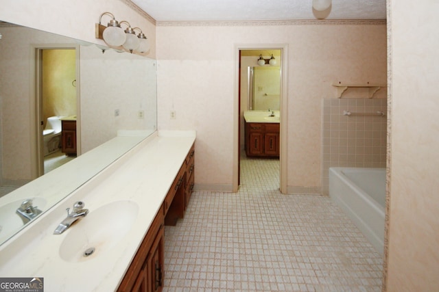 bathroom with ornamental molding, a tub to relax in, vanity, and baseboards