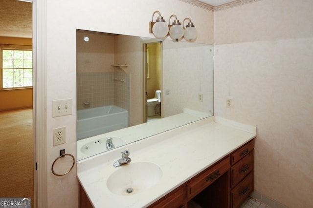 bathroom with a tub to relax in, vanity, and toilet