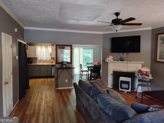 living room featuring a textured ceiling, crown molding, sink, ceiling fan, and wood-type flooring