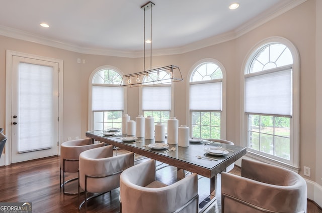 dining area with dark wood-type flooring, a healthy amount of sunlight, and ornamental molding