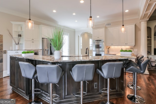 kitchen featuring backsplash, stainless steel appliances, dark hardwood / wood-style flooring, and a spacious island