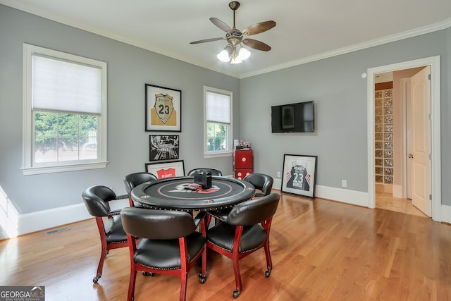 dining area with ceiling fan, light hardwood / wood-style floors, and ornamental molding