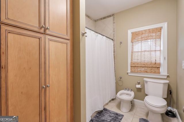 bathroom featuring tile patterned floors, a bidet, and toilet