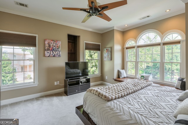 bedroom with ceiling fan, crown molding, light carpet, and multiple windows