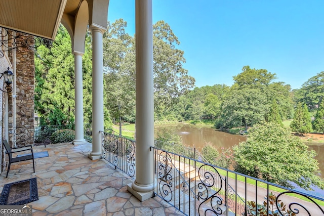 view of patio featuring a balcony and a water view