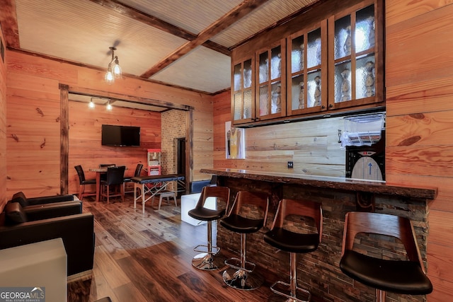 bar featuring beam ceiling, wood walls, and dark hardwood / wood-style floors