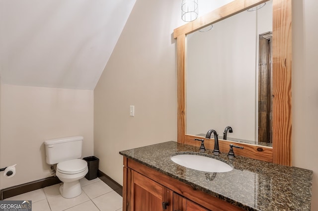 bathroom featuring tile patterned floors, vaulted ceiling, vanity, and toilet