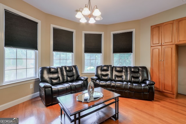 living room with an inviting chandelier and light wood-type flooring