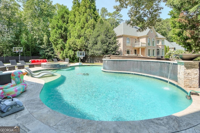 view of pool with an in ground hot tub, a patio, and pool water feature