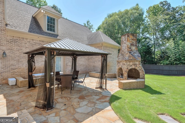 view of patio / terrace featuring a gazebo and an outdoor stone fireplace