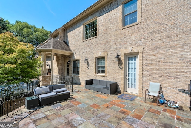 back of property with an outdoor living space and a patio area