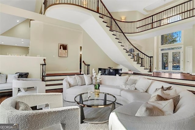 living room featuring a high ceiling, french doors, and wood-type flooring