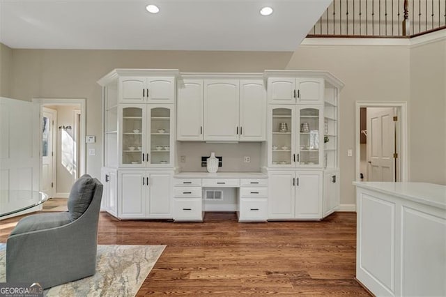 bar with white cabinetry and dark hardwood / wood-style flooring