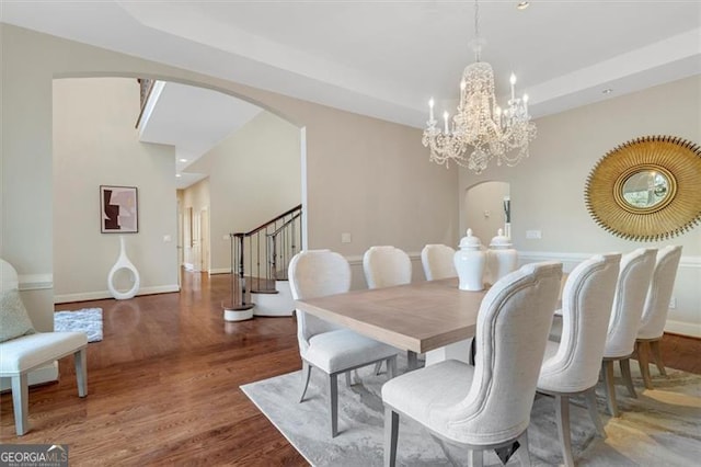 dining room featuring a raised ceiling, a chandelier, and dark hardwood / wood-style floors