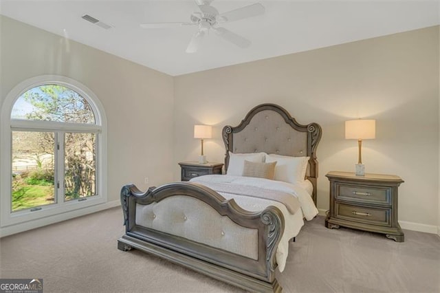 bedroom with ceiling fan, light carpet, and multiple windows