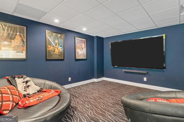 home theater featuring carpet flooring and a drop ceiling