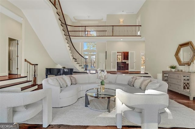 living room featuring hardwood / wood-style floors and a towering ceiling