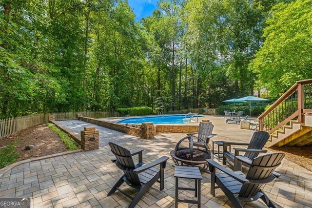 view of patio / terrace featuring a fenced in pool and an outdoor fire pit