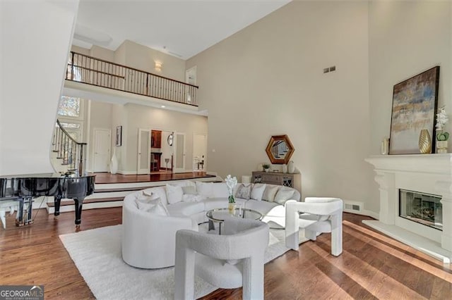 living room featuring hardwood / wood-style flooring and a towering ceiling