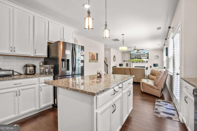 kitchen featuring a kitchen island, open floor plan, white cabinets, and stainless steel fridge with ice dispenser