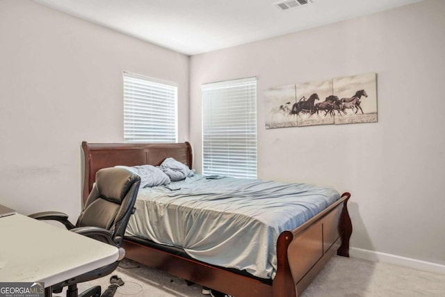 bedroom with baseboards and light colored carpet