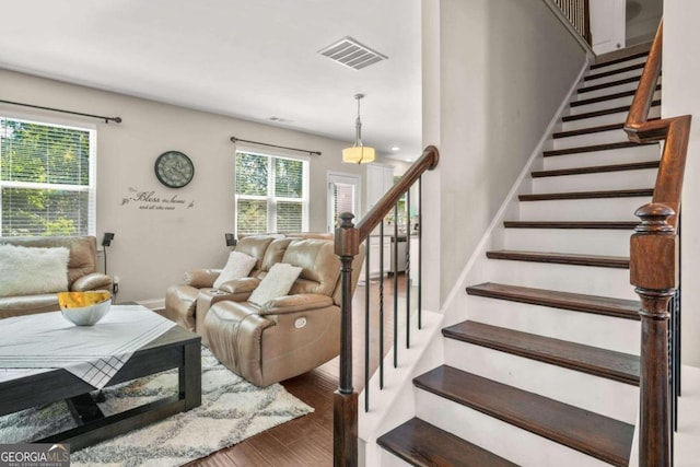 staircase with visible vents, baseboards, and wood finished floors