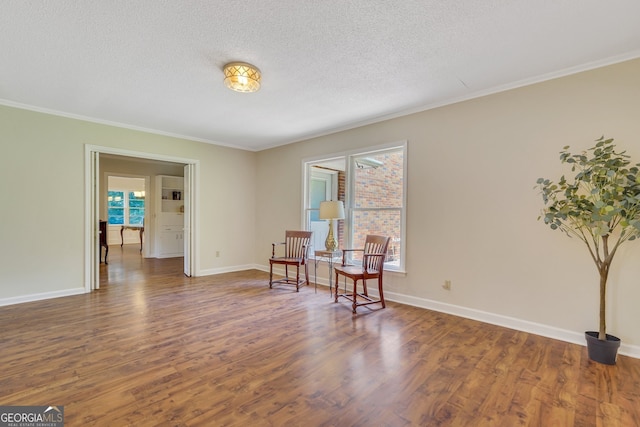 living area featuring hardwood / wood-style flooring, a textured ceiling, and a wealth of natural light