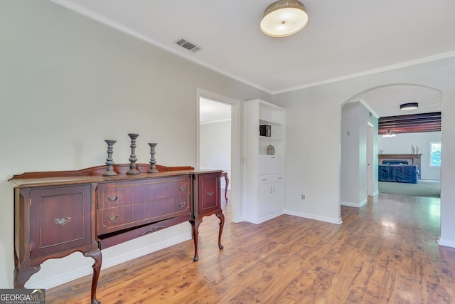 interior space featuring crown molding, a fireplace, and light hardwood / wood-style flooring