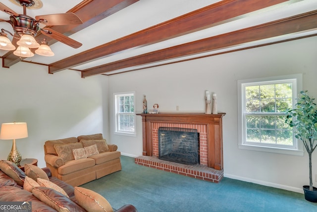 carpeted living room with ceiling fan, a fireplace, beamed ceiling, and a healthy amount of sunlight