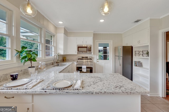 kitchen featuring pendant lighting, light tile patterned flooring, appliances with stainless steel finishes, sink, and kitchen peninsula