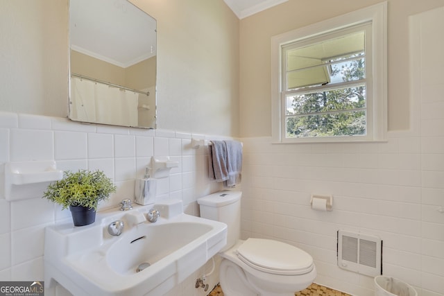 bathroom with toilet, backsplash, tile walls, ornamental molding, and sink