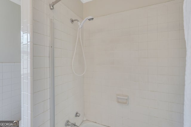 interior details with tiled shower / bath combo