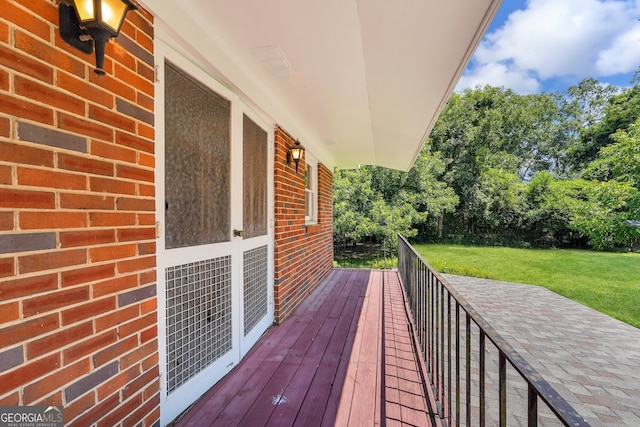 wooden terrace featuring a lawn