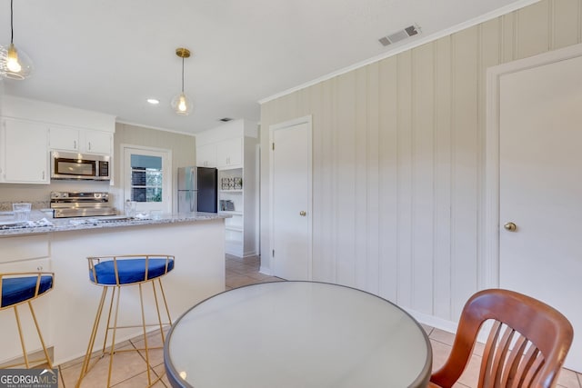 dining area featuring light tile patterned flooring and ornamental molding