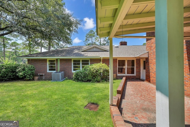 rear view of house featuring a lawn and central air condition unit