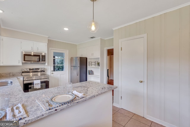 kitchen with white cabinets, stainless steel appliances, light stone counters, and hanging light fixtures