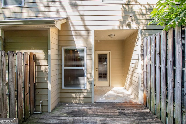 entrance to property featuring fence and a deck