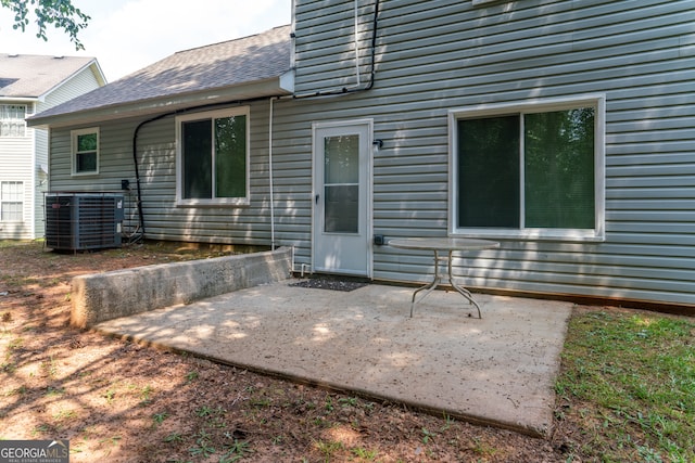 back of house with central AC unit and a patio