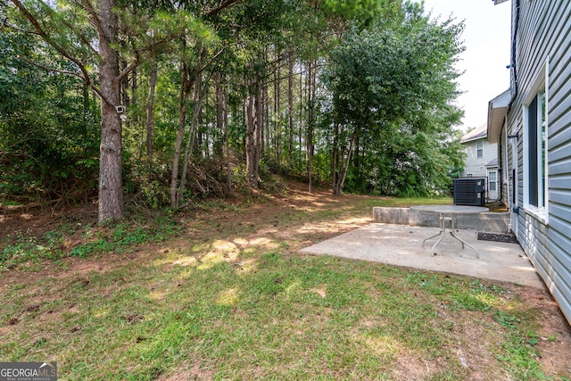 view of yard with central AC unit and a patio