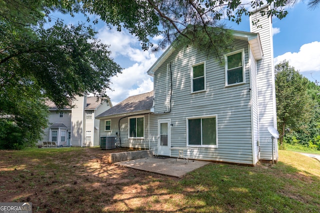 back of house featuring a lawn, cooling unit, and a patio area