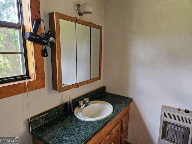 bathroom featuring a wealth of natural light, vanity, and heating unit