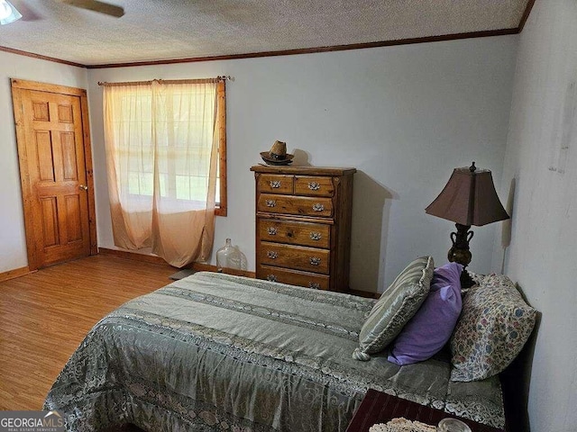 bedroom featuring a textured ceiling, ceiling fan, and light hardwood / wood-style floors