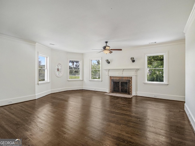 unfurnished living room with a fireplace, plenty of natural light, dark hardwood / wood-style floors, and ornamental molding