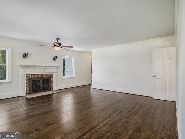 unfurnished living room with dark hardwood / wood-style flooring, a brick fireplace, ceiling fan, and ornamental molding